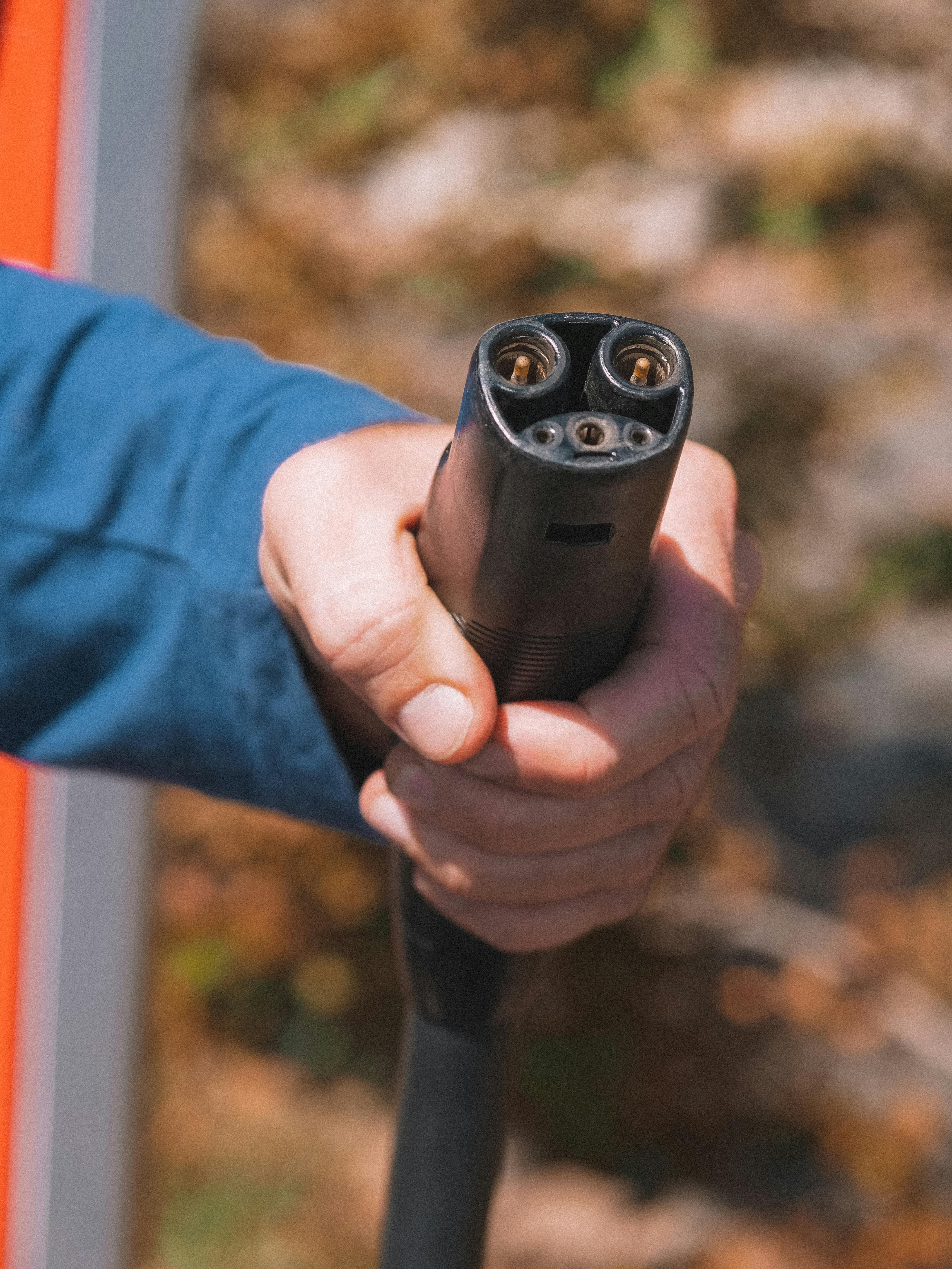 Hand holding an EV charger, part of a connected modern energy portfolio