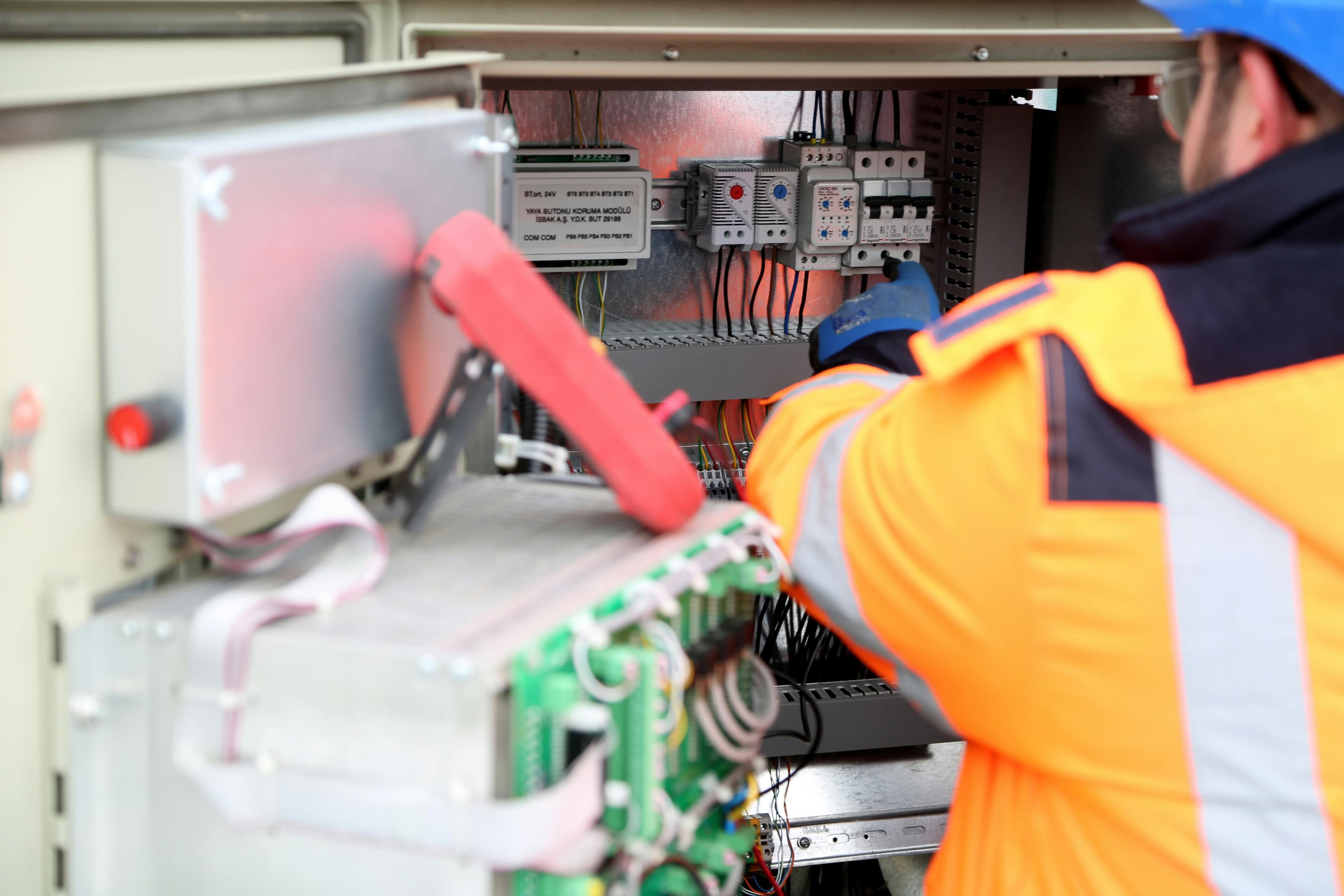 Field technician in safety gear servicing electrical equipment